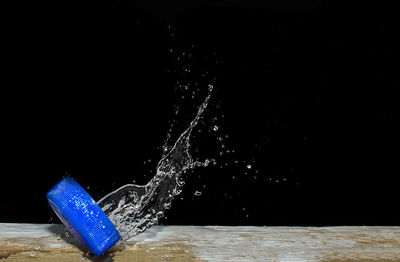 Close-up of blue water splashing against black background