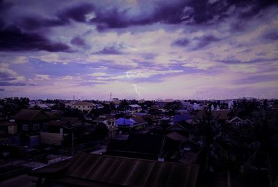 View of cityscape against cloudy sky