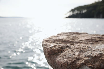 Close-up of rocks by sea against sky