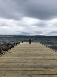 Wooden pier over sea against sky