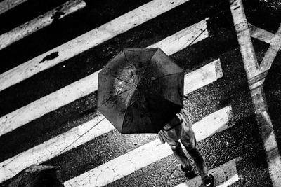 Person with umbrella crossing road