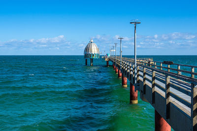 Pier over sea against blue sky