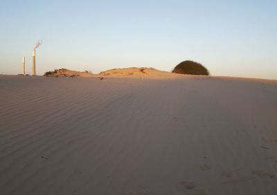 Sand dunes in desert against clear sky