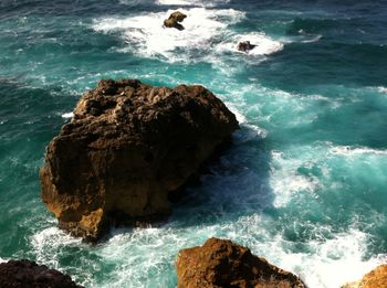 High angle view of sea waves splashing on rocks