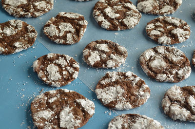 Homemade chocolate crinkle cookies on blue paper