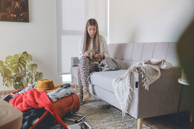 Rear view of woman sitting on sofa at home