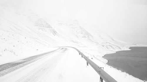 Snow covered road passing through landscape