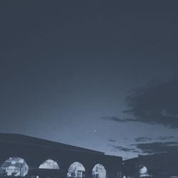 Low angle view of silhouette arch bridge against sky at night