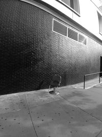 Shadow of person on footpath against building