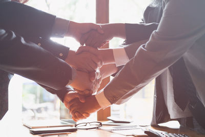 Midsection of business people giving handshake in office