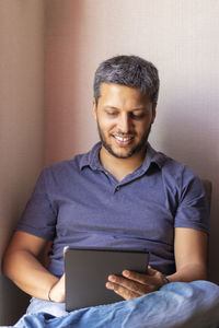 Smiling man using digital tablet