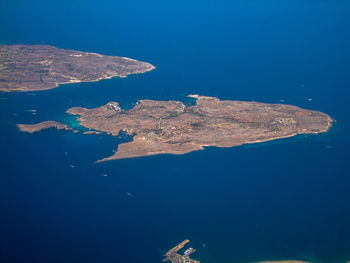 High angle view of sea and rocks against blue sky