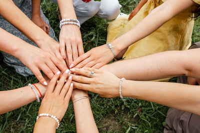 Low section of friends stacking hands