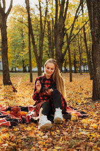 Life style portrait of happy woman in fall park. beautiful girl on the nature picnic camping. 