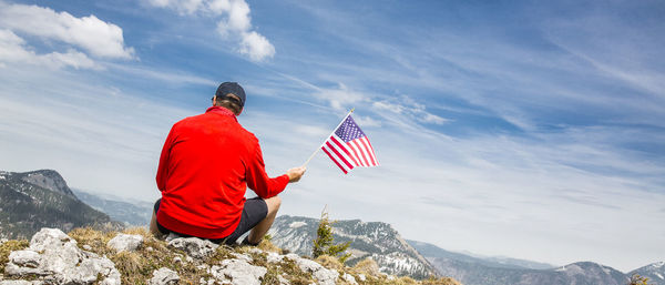 Rear view of person on rocks against mountain range