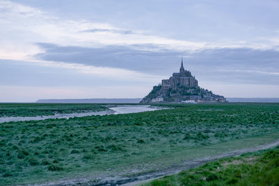 View of building on beach against cloudy sky