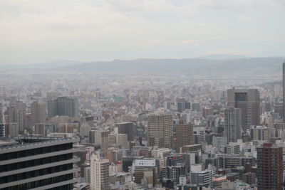 Aerial view of buildings in city against sky