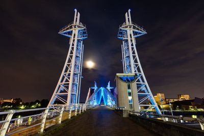 Illuminated tower bridge against sky at night