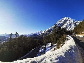 Scenic view of snowcapped mountains against clear blue sky