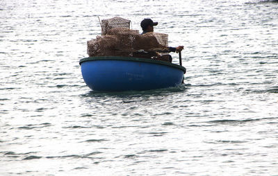 Rear view of man in boat sailing in sea