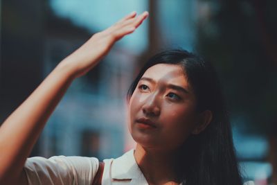 Close-up of woman shielding eyes while looking away