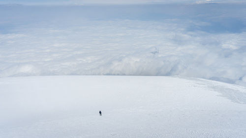 Solo mountaineer walking big glacier field above the clouds, mount ararat in turkey