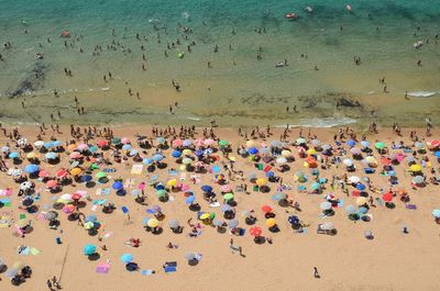 Elevated view of crowded beach with multicolored umbrellas