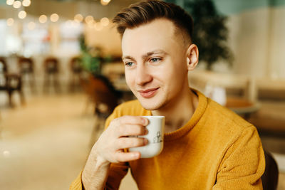 Portrait of smiling man holding coffee cup