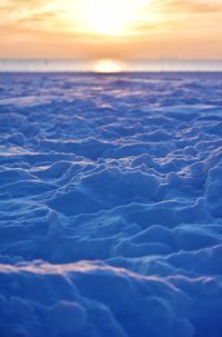 Beach at the baltic sea during sunrise covered with snow