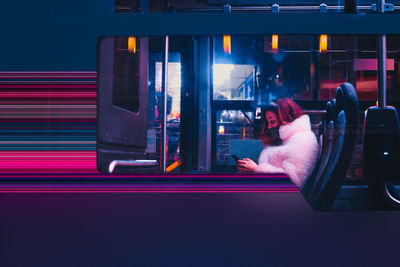 Woman with smartphone in bus at night