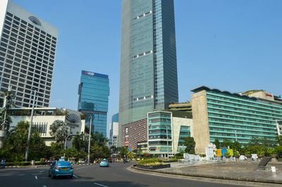 Modern buildings in city against clear blue sky