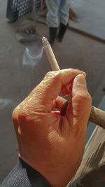 Cropped hand of man holding cigarette