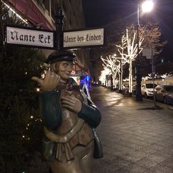 Full length of a man with text on tree at night