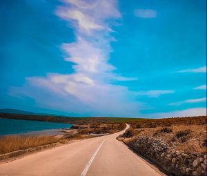 Empty road along landscape and blue sky