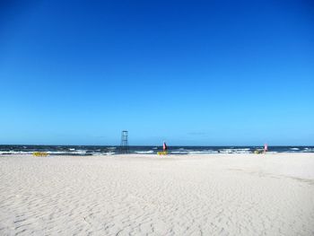 Scenic view of beach against clear blue sky