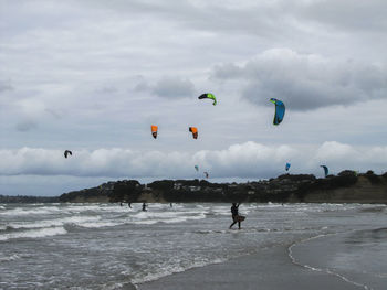 People on beach against sky