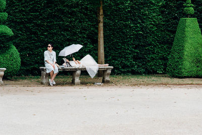 Man sitting on bench against trees
