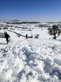 People on snow covered mountain against sky