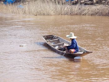 Rear view of man sitting in river