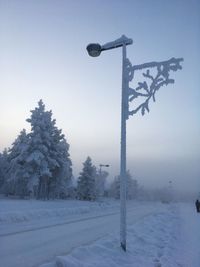 Street light on snow covered field against sky