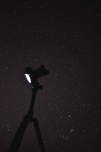 Low angle view of silhouette camera against sky at night