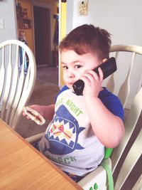 Portrait of cute boy sitting at home