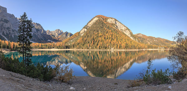 Scenic view of lake and mountains against clear blue sky