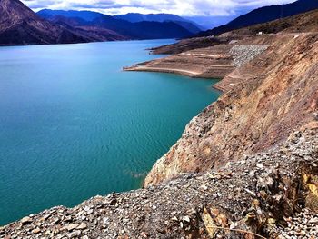 High angle view of lake by mountains against sky