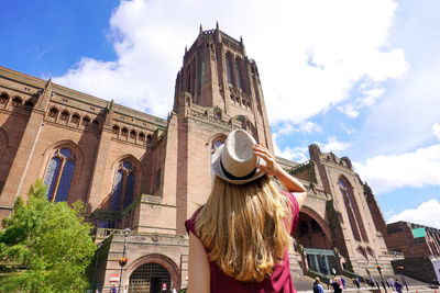Back view of traveler girl visiting the cathedral church of christ in liverpool, england.