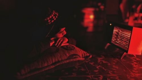 Young man lying in darkroom