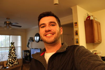 Portrait of smiling man at home during christmas