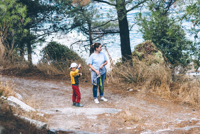 Mother and son standing by trees