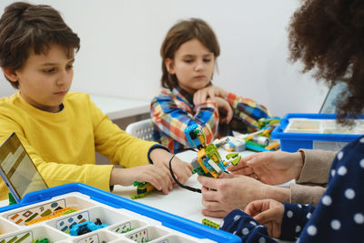 Students in school computer coding class building and learning to program robot vehicle. multi