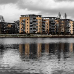 River by buildings against sky